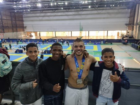Um grupo de jovens posa para uma foto em uma academia.