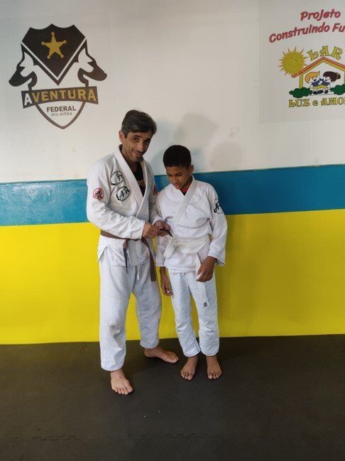 Um homem e um menino estão em frente a uma parede que diz aventura