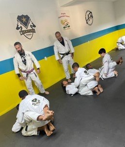 Um grupo de pessoas pratica artes marciais em uma academia.